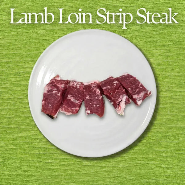 Raw lamb loin strip steak on a white plate with a green background
