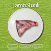 Photograph of a raw lamb shank centered on a white plate against a vibrant green textured background, topped by the text "Lamb Shank" and accompanied by informational badges highlighting its Halal, Natural, and Pasture Raised attributes