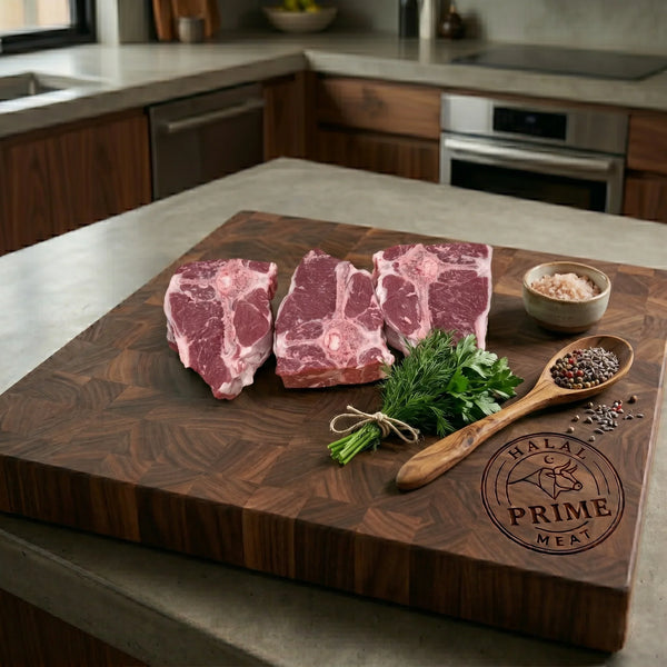 Three raw lamb T-Bone steaks on a wooden cutting board with herbs and spices.