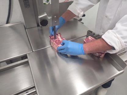 butcher cutting lamb chuck on a bandsaw